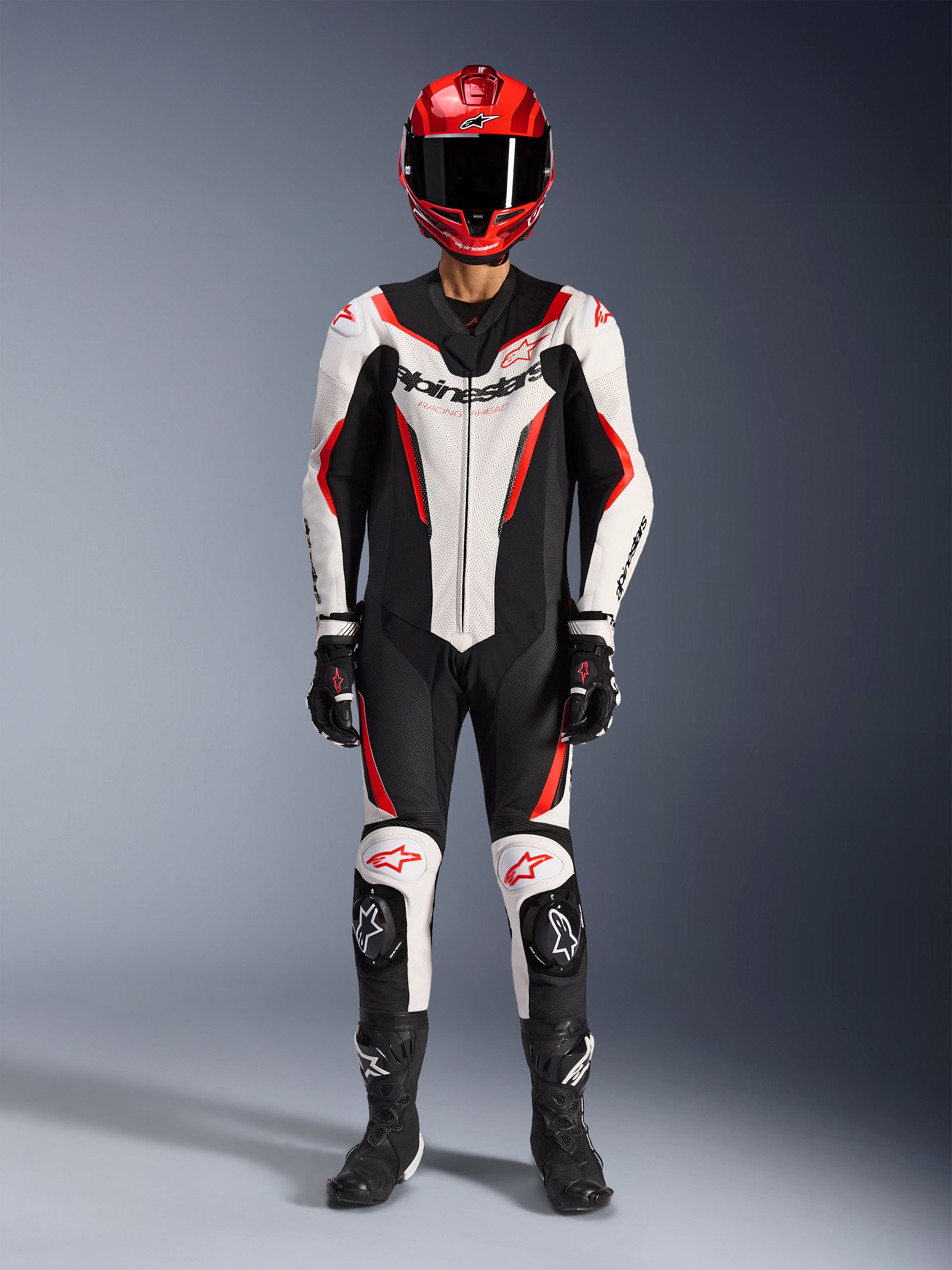 Alpinestars GP Force V2 läderställ - 1 del, vit, svart och röd fluo, komplett racingutrustning inklusive röd hjälm, svarta handskar och stövlar, med aerodynamisk design och Alpinestars-logotyper på bröst och knän