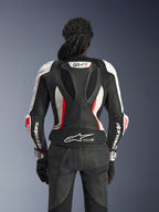 Vy bakifrån av Alpinestars Stella GP-R7 2-delat läderställ i svart, vitt och Red Fluo, med en aerodynamisk puckel med GP-R7-märkning, perforerade läderpaneler, dragspelspaneler och Tech-Air® Ready-logotyp på nedre delen av ryggen.