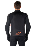 Alpinestars T-Jaws V4 Waterproof Jacket, sedd bakifrån, svart med röd fluo, röd Alpinestars-logotyp på nedre delen av ryggen, teknisk textilkonstruktion, bärs med svarta byxor och handskar för en komplett sportig look