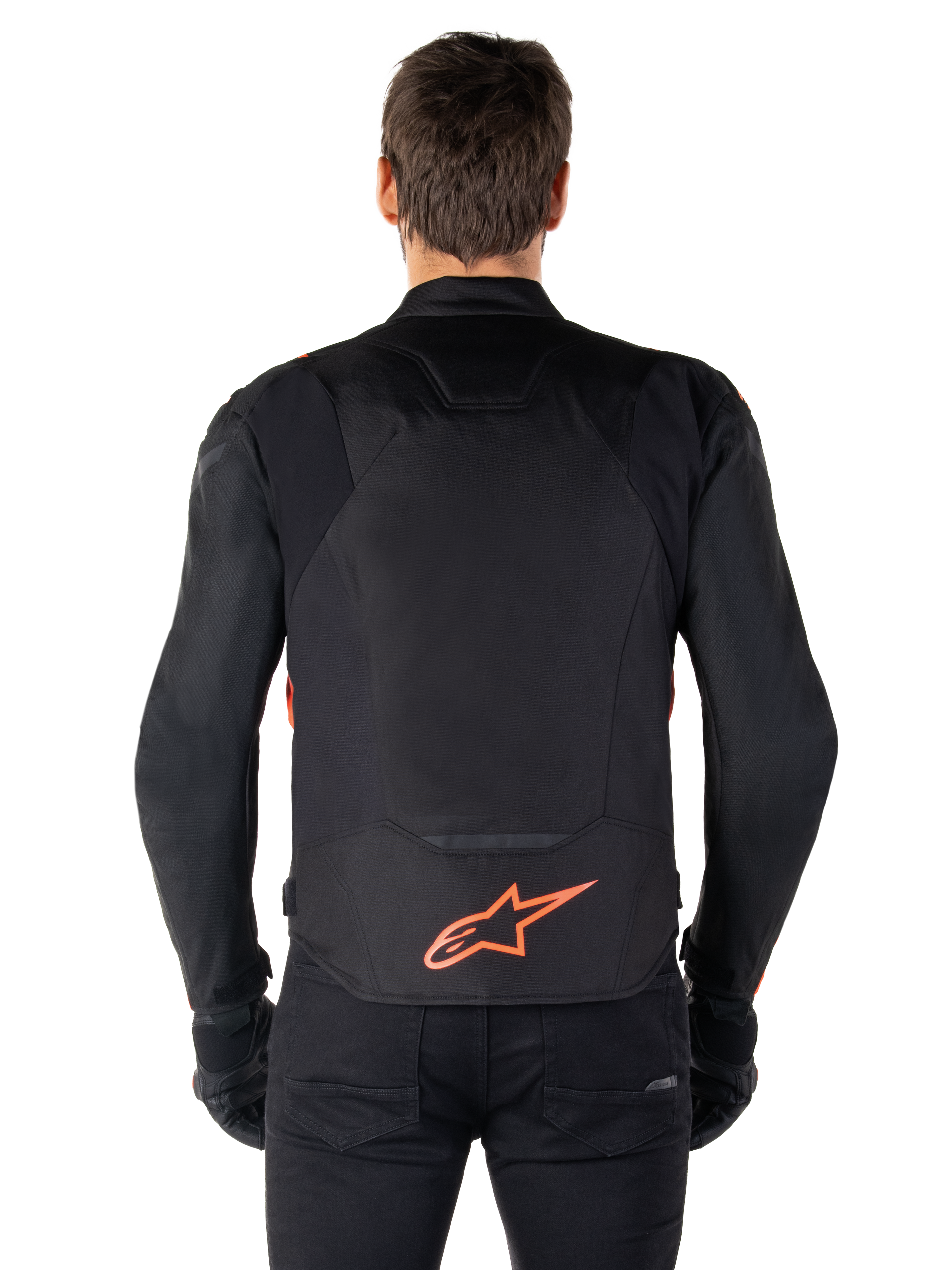 Alpinestars T-Jaws V4 Waterproof Jacket, sedd bakifrån, svart med röd fluo, röd Alpinestars-logotyp på nedre delen av ryggen, teknisk textilkonstruktion, bärs med svarta byxor och handskar för en komplett sportig look