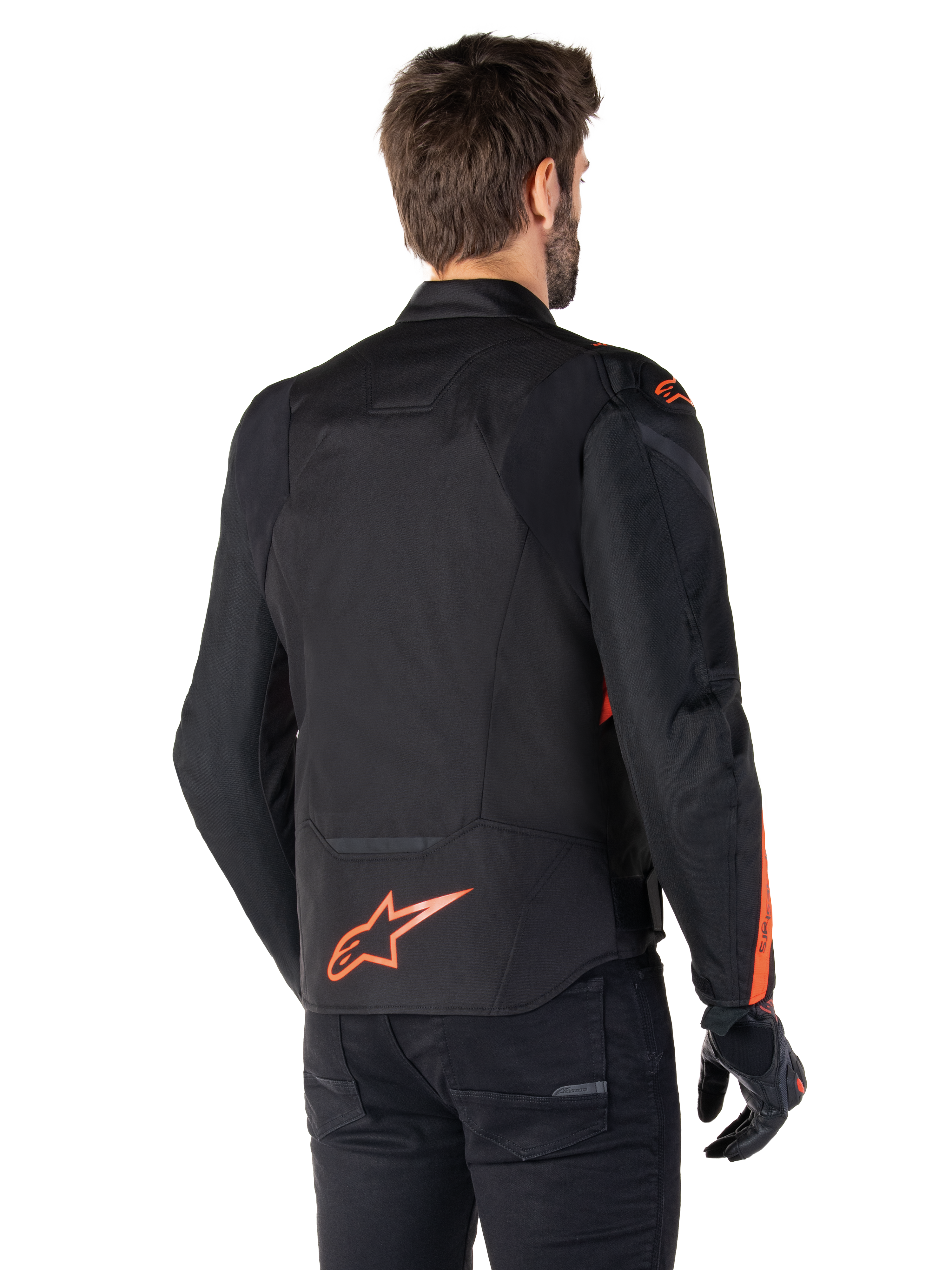 Manlig modell bär Alpinestars T-Jaws V4 Waterproof Jacket sedd bakifrån, svart med fluoröda detaljer, med en fluoröd logotyp på nedre delen av ryggen och detaljer på axlar och ärmar, sportig motorcykelutrustning.