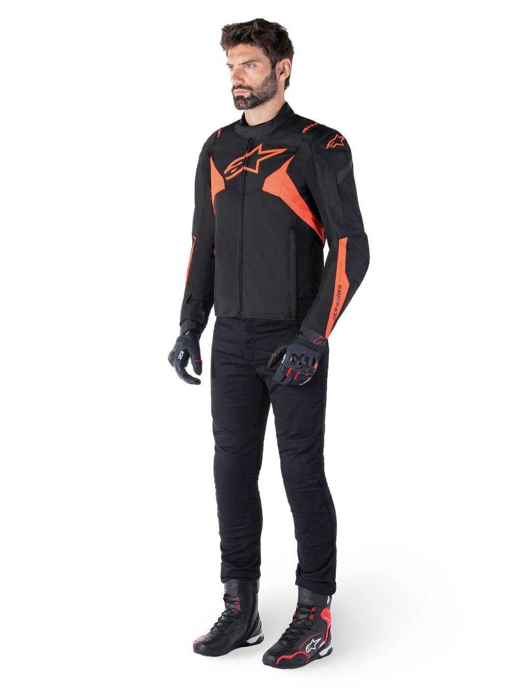 Alpinestars T-Jaws V4 Waterproof Jacket, svart och röd fluo, bärs av en manlig modell med svarta byxor, handskar och stövlar, med lysande orangea detaljer och Alpinestars-logotyp, sportig design för motorcykelkörning