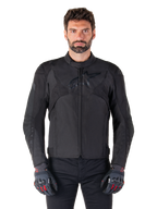 Alpinestars T-Jaws V4 Waterproof Jacket, Black Motorcycle Sport Jacket, worn by a man with black gloves featuring red accents, reinforced shoulders and arms, sleek design with subtle chest logo, textile all-weather riding gear