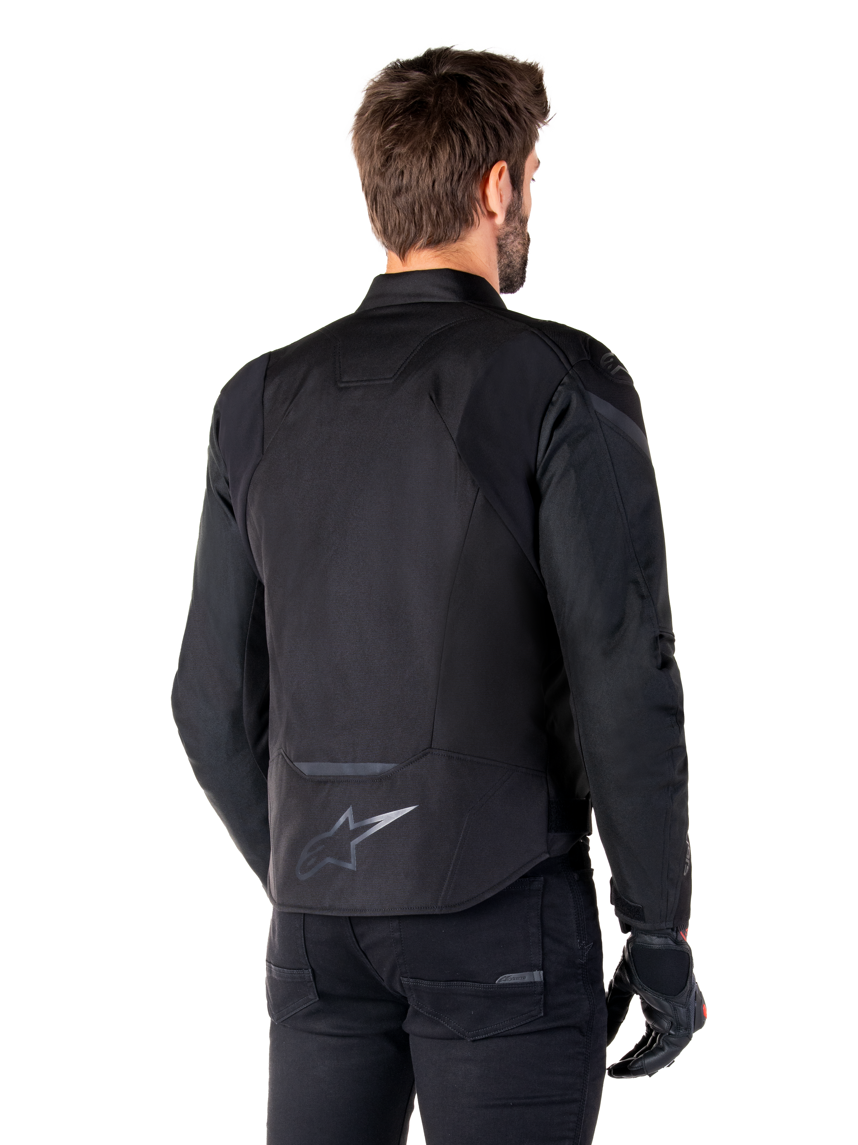 Alpinestars T-Jaws V4 Waterproof Jacket, Black, back view on model, featuring a reflective Alpinestars logo on the lower back, extended rear for coverage, sporty textile design with tonal panels, worn with black motorcycle gloves