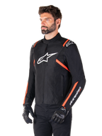 Alpinestars T-SPS V2 vattentät jacka, svart, vit och fluorescerande röd, bärs av en manlig modell med svarta handskar och byxor, med en vit Alpinestars-logotyp på bröstet och fluorescerande röda detaljer på axlar och ärmar, sportig textildesign