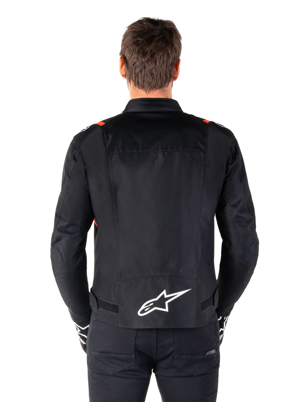Alpinestars T-SPS V2 Waterproof-jacka, svart med vita och röd-fluo-detaljer, vy bakifrån med en stor vit Alpinestars-logotyp på nedre ryggen, sportig textiljacka för motorcykel, bärs med svarta byxor och handskar