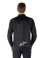 Alpinestars T-SPS V2 Waterproof-jacka, svart med vita och röd-fluo-detaljer, vy bakifrån med en stor vit Alpinestars-logotyp på nedre ryggen, sportig textiljacka för motorcykel, bärs med svarta byxor och handskar