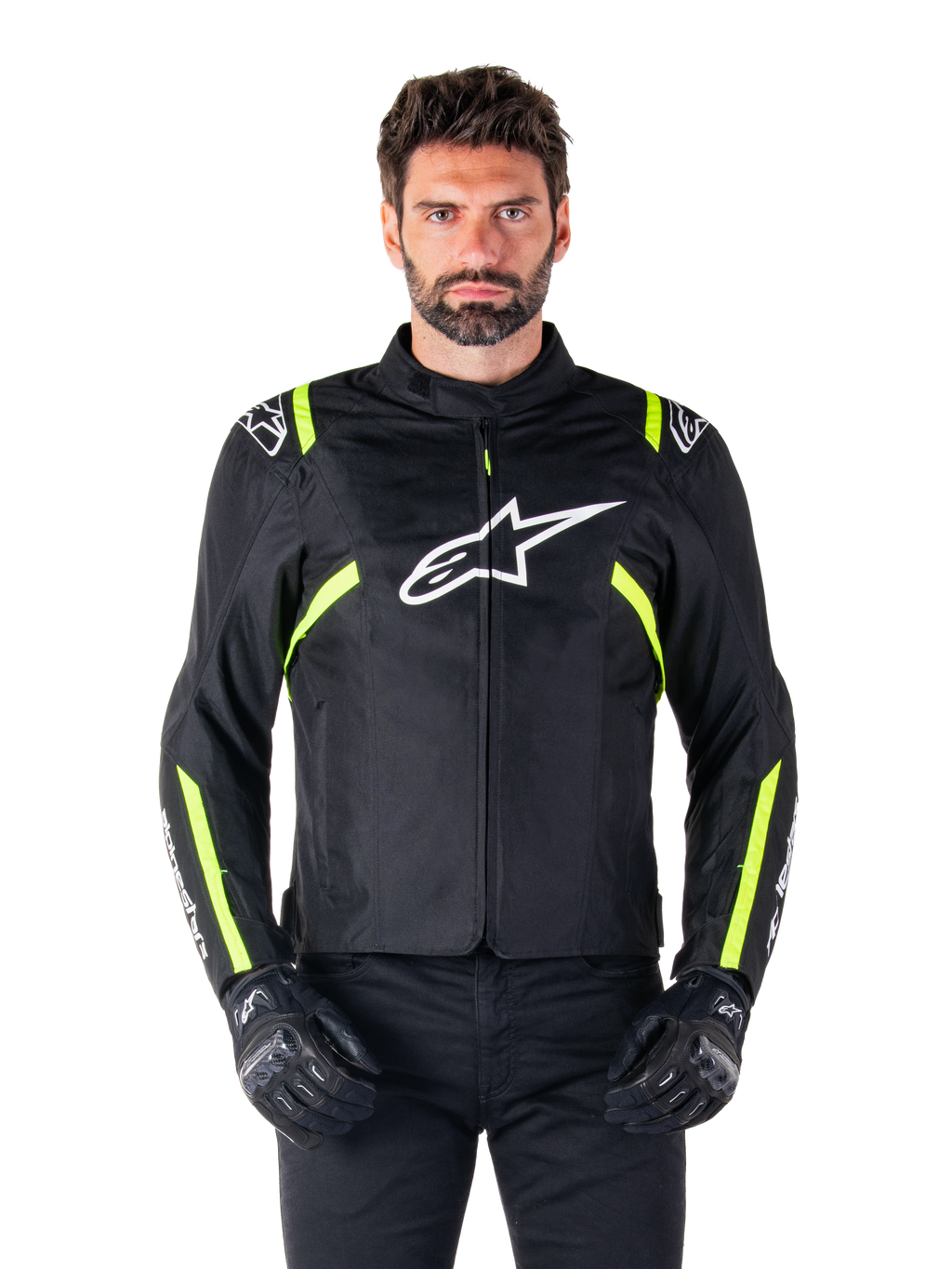 Alpinestars T-SPS V2 Waterproof Jacket, motorcykeljacka, svart med vita och neongula detaljer, bärs av en modell med svarta handskar, vit stjärnlogotyp på bröstet och neongula ränder på ärmar och axlar, sportig textilutrustning för körning i alla väder