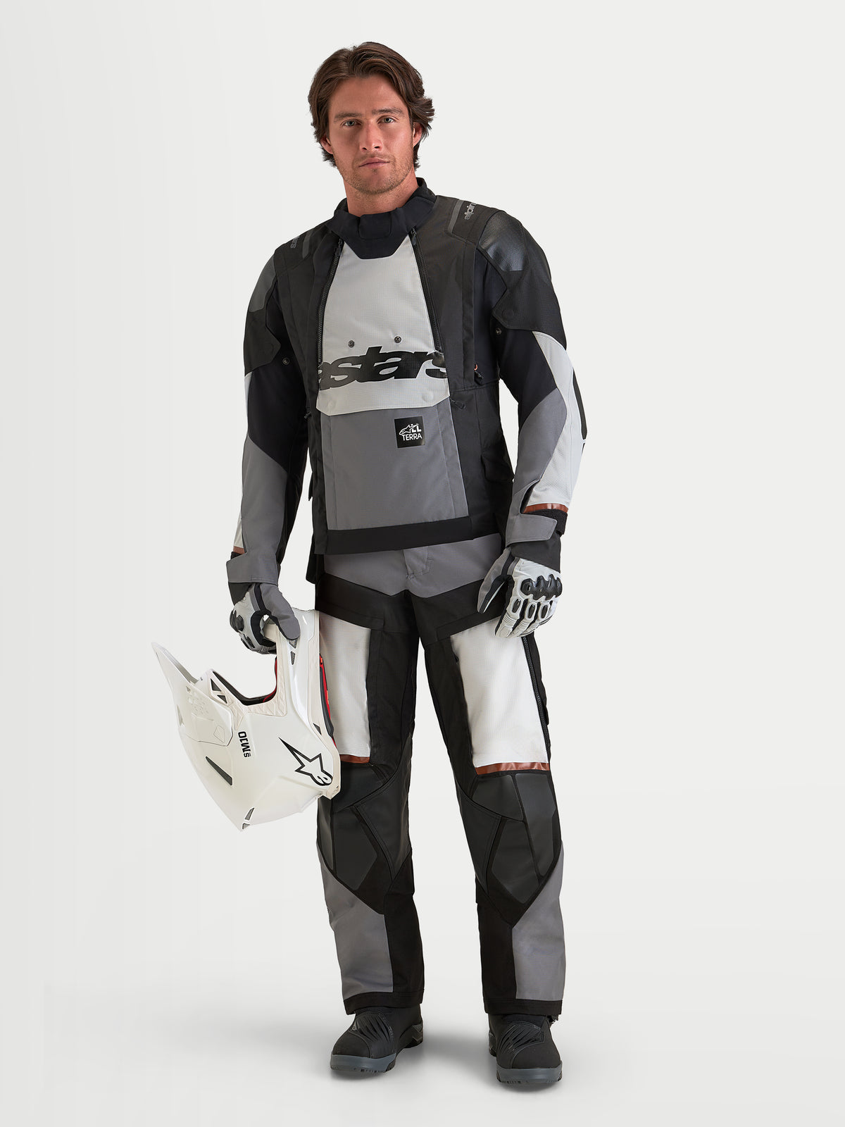 Alpinestars Harok V2 Drystar jacka, äventyrs-MC-jacka för herr, mörkgrå, isgrå och svart, vattentät textilkonstruktion med CE-certifierat skydd, på en manlig modell som håller i en vit hjälm