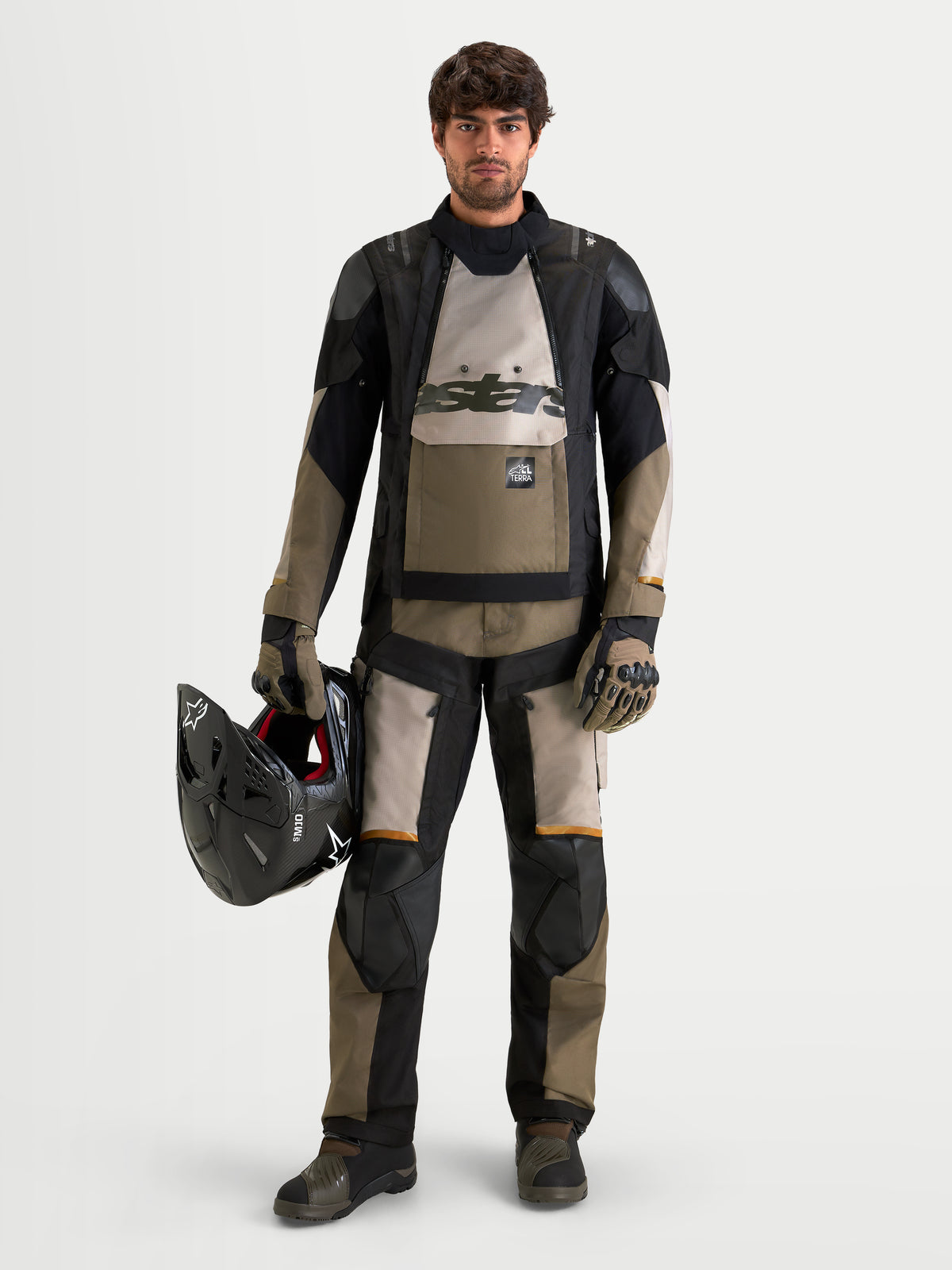 Alpinestars Harok V2 Drystar jacka, äventyrs-motorcykeljacka för herr i aluminium, brunt och svart, bärs med matchande utrustning medan en hjälm hålls i handen