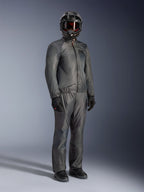 Förare som bär Alpinestars Borrego Drystar®-jacka i Warm Gray, komplett äventyrsutrustning med matchande grå byxor, svart helhjälm med goggles och svarta handskar, med en stilren vattentät textildesign.