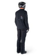 Alpinestars AMT-8 Stretch Drystar® XF-jacka, svart, vy bakifrån av en förare som bär jackan med matchande svarta byxor och en svart hjälm, med 'Alpinestars Motion Technology'-logotyp på ryggen, tekniskt stretchmaterial för äventyrsmotorcykelkörning