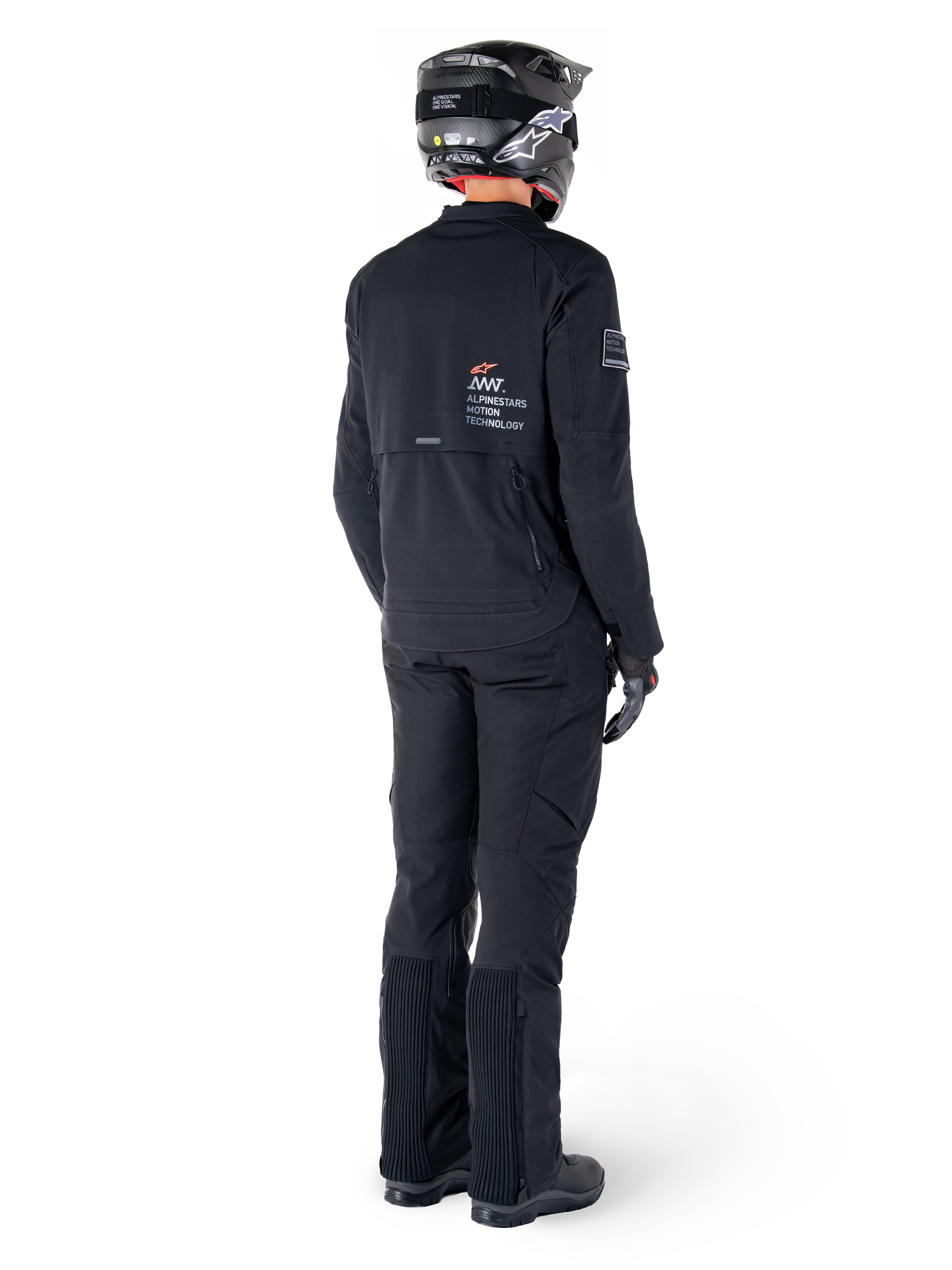 Alpinestars AMT-8 Stretch Drystar® XF-jacka, svart, vy bakifrån av en förare som bär jackan med matchande svarta byxor och en svart hjälm, med 'Alpinestars Motion Technology'-logotyp på ryggen, tekniskt stretchmaterial för äventyrsmotorcykelkörning