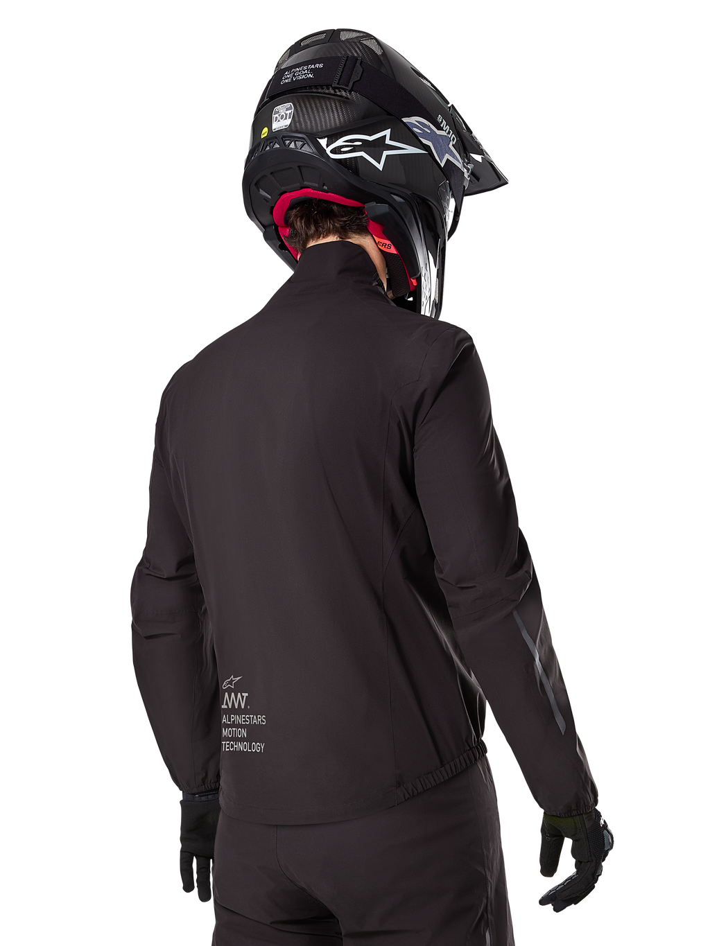 Alpinestars AMT-8 Stretch Drystar® XF-foder, svart vattentätt jackfoder, vy bakifrån på en förare med svart hjälm och handskar, Alpinestars Motion Technology-märkning på nedre delen av ryggen, minimalistisk och funktionell design för äventyrskörning.