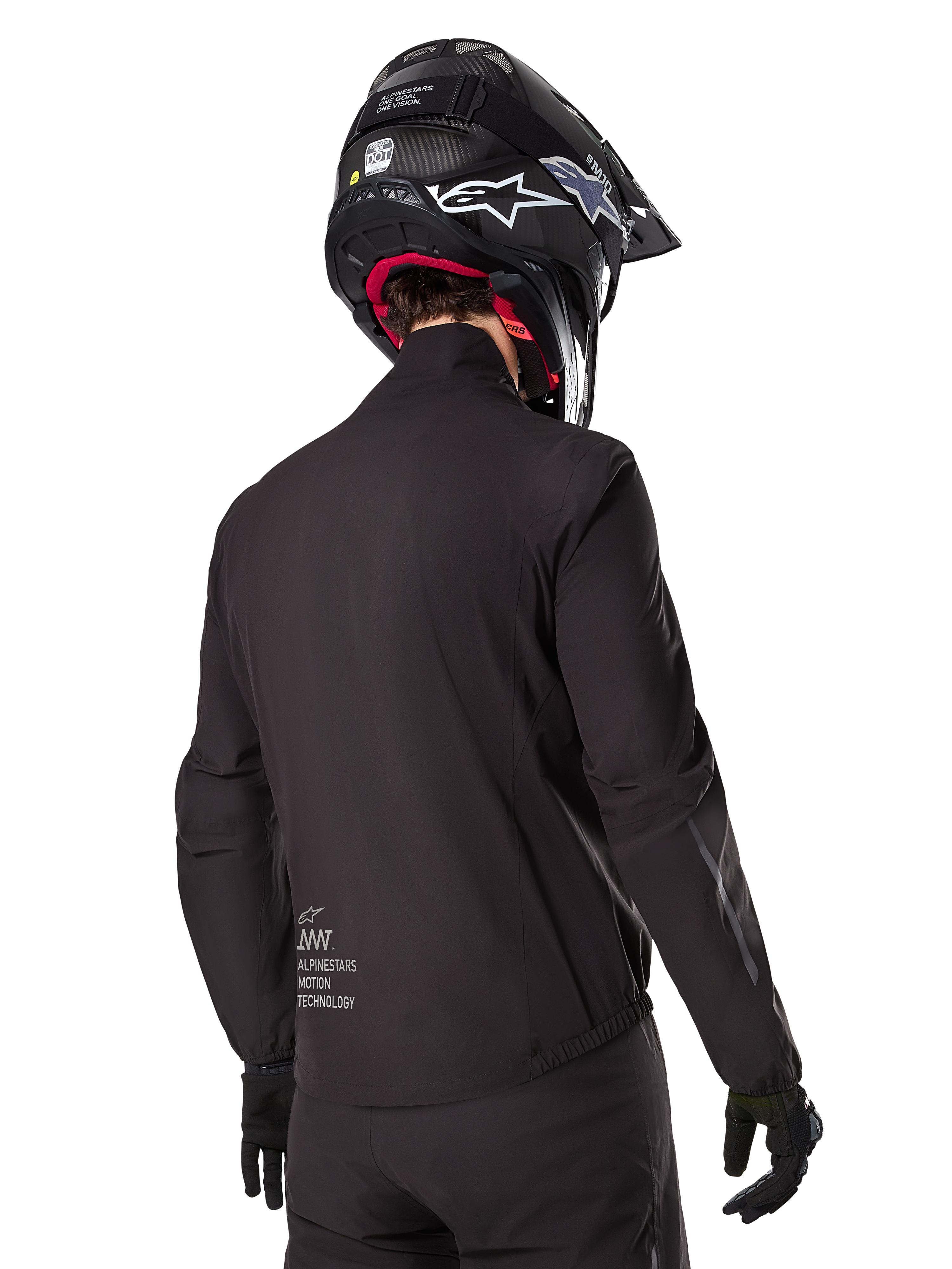 Alpinestars AMT-8 Stretch Drystar® XF-foder, svart vattentätt jackfoder, vy bakifrån på en förare med svart hjälm och handskar, Alpinestars Motion Technology-märkning på nedre delen av ryggen, minimalistisk och funktionell design för äventyrskörning.