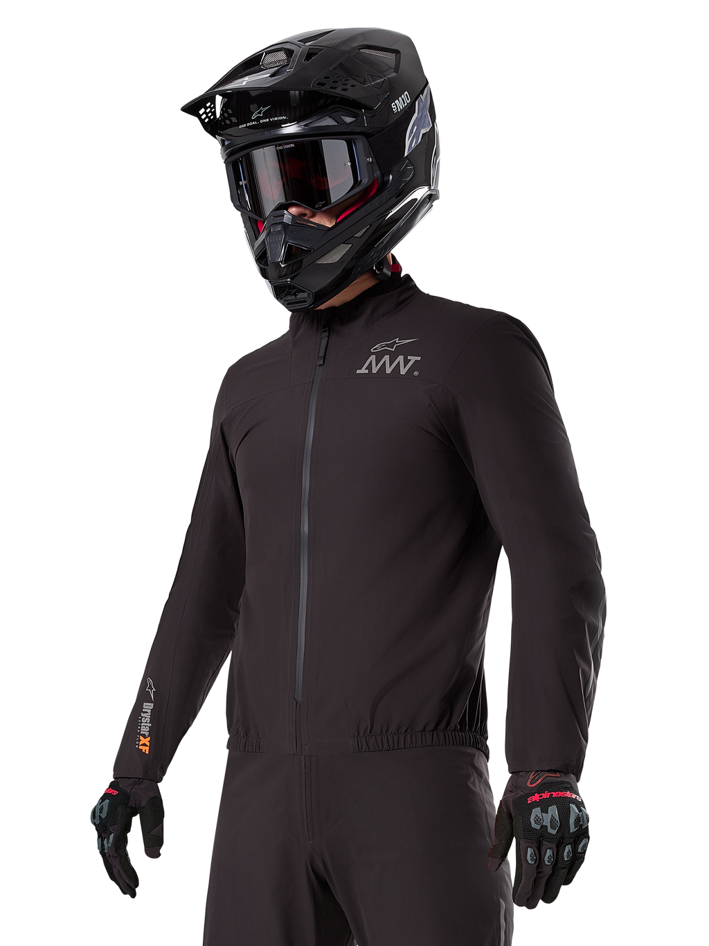 Förare som bär Alpinestars AMT-8 Stretch Drystar® XF Liner, svart vind- och vattentät stretchjacka med AMT-logotyp på bröstet och Drystar XF-märkning på ärmen, kombinerat med en svart adventurehjälm och skyddshandskar.
