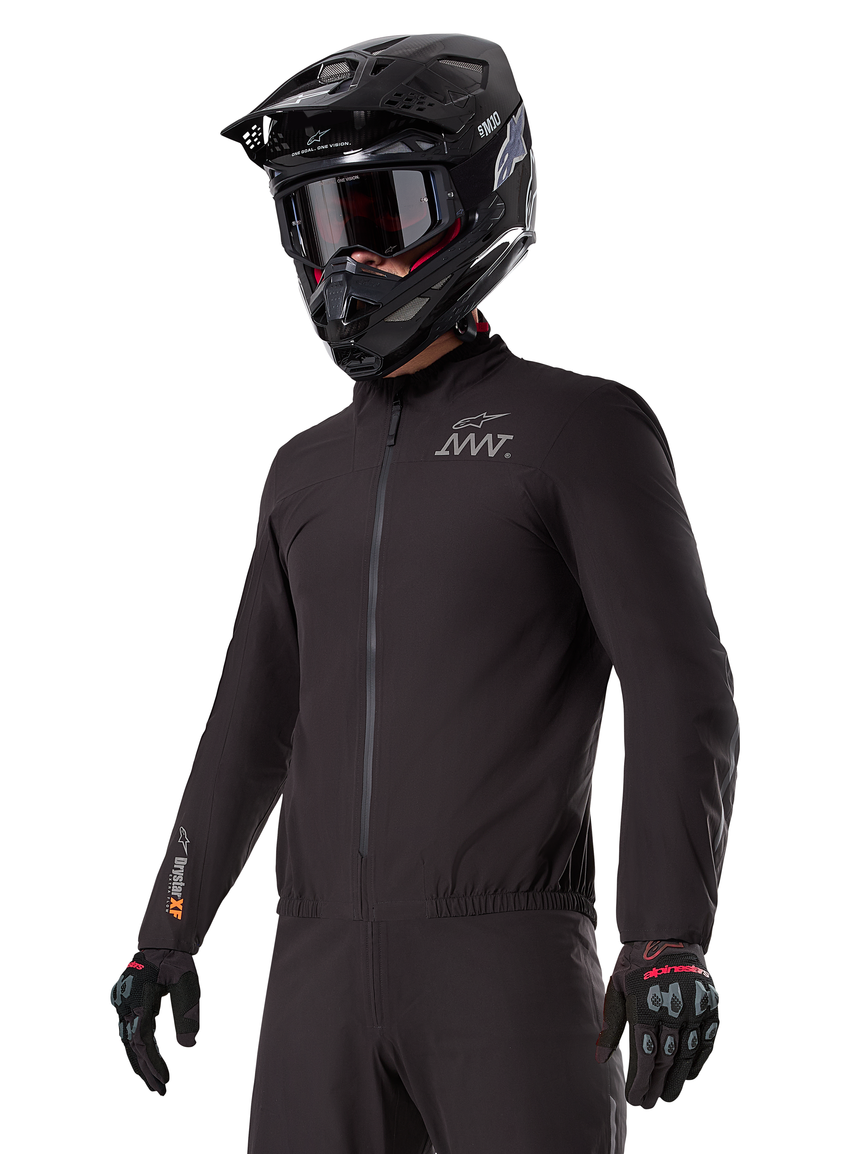 Förare som bär Alpinestars AMT-8 Stretch Drystar® XF Liner, svart vind- och vattentät stretchjacka med AMT-logotyp på bröstet och Drystar XF-märkning på ärmen, kombinerat med en svart adventurehjälm och skyddshandskar.