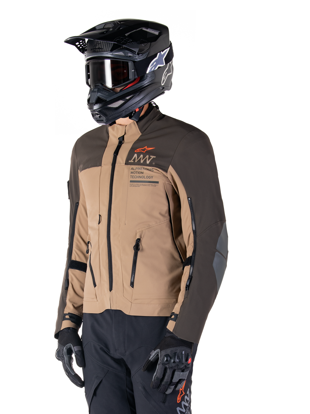 Alpinestars AMT-8 Stretch Drystar® XF jacka, äventyrsmotorcykeljacka, mörkbrun och mörk khaki, bärs med en svart terränghjälm och goggles, med Alpinestars Motion Technology-logotyp och ventilationsöppningar med dragkedja.