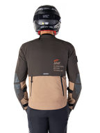 Alpinestars AMT-8 Stretch Drystar® XF-jacka, baksida, tvåtonad design i mörkbrunt och mörk khaki, med Alpinestars Motion Technology-märkning, bakre cargo-ficka med dragkedja och skyddande armbågspaneler, motorcykelkläder för adventure touring