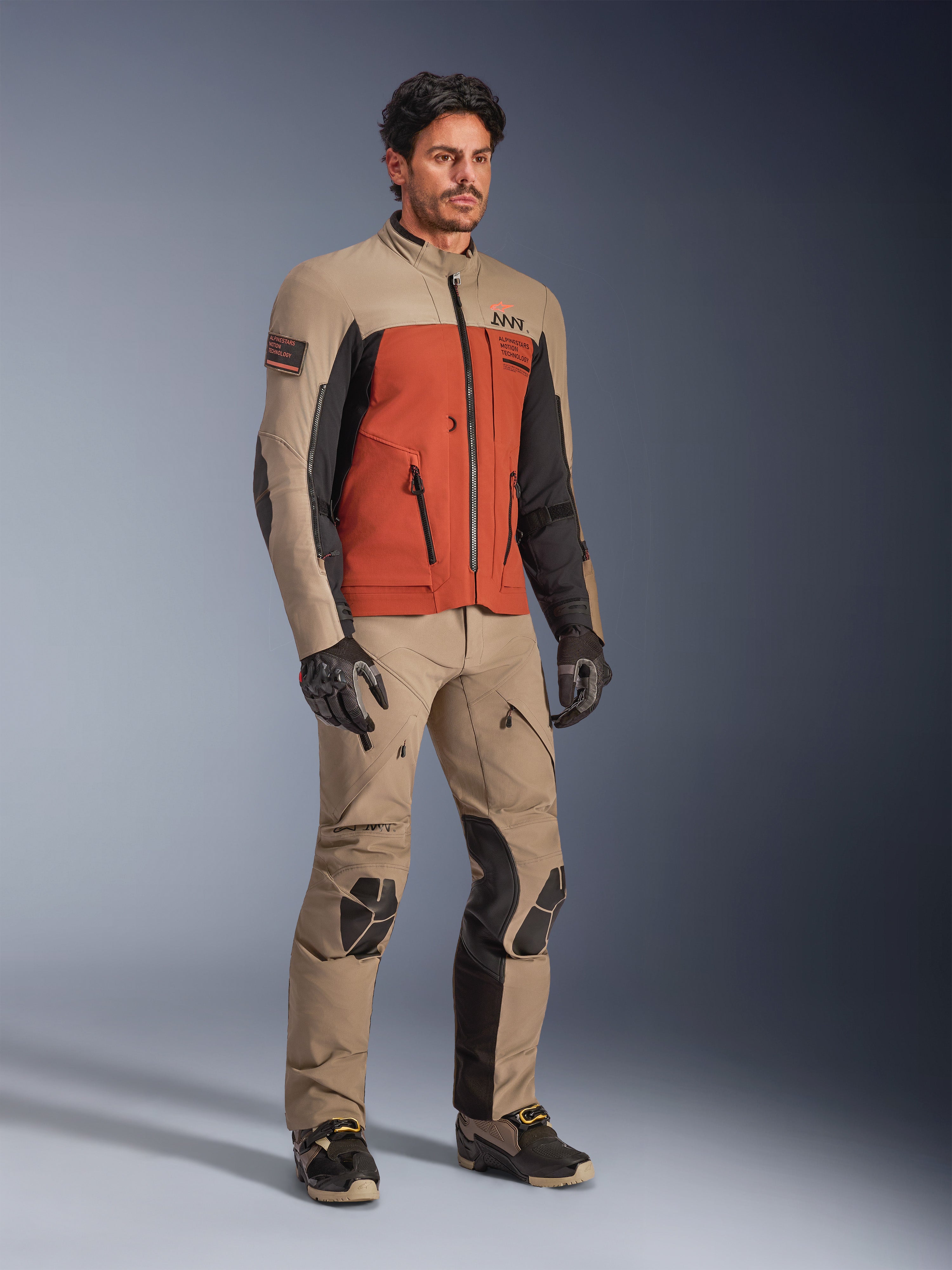 Alpinestars AMT-8 Stretch Drystar® XF Jacket, Walnut Rust Black äventyrsjacka för motorcykel, bärs med matchande tekniska byxor och handskar, flerfärgad design med beige, rostorange och svarta paneler, designad för långdistans-touring.