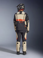 Alpinestars Halo Pro Drystar® XF laminerad jacka, äventyrsmotorcykeljacka, Mastic Black, ryggvy av en förare i matchande byxor och svart hjälm, med framträdande orange Alpinestars-logotyp och modulära ventilationspaneler för mångsidig äventyrskörning.
