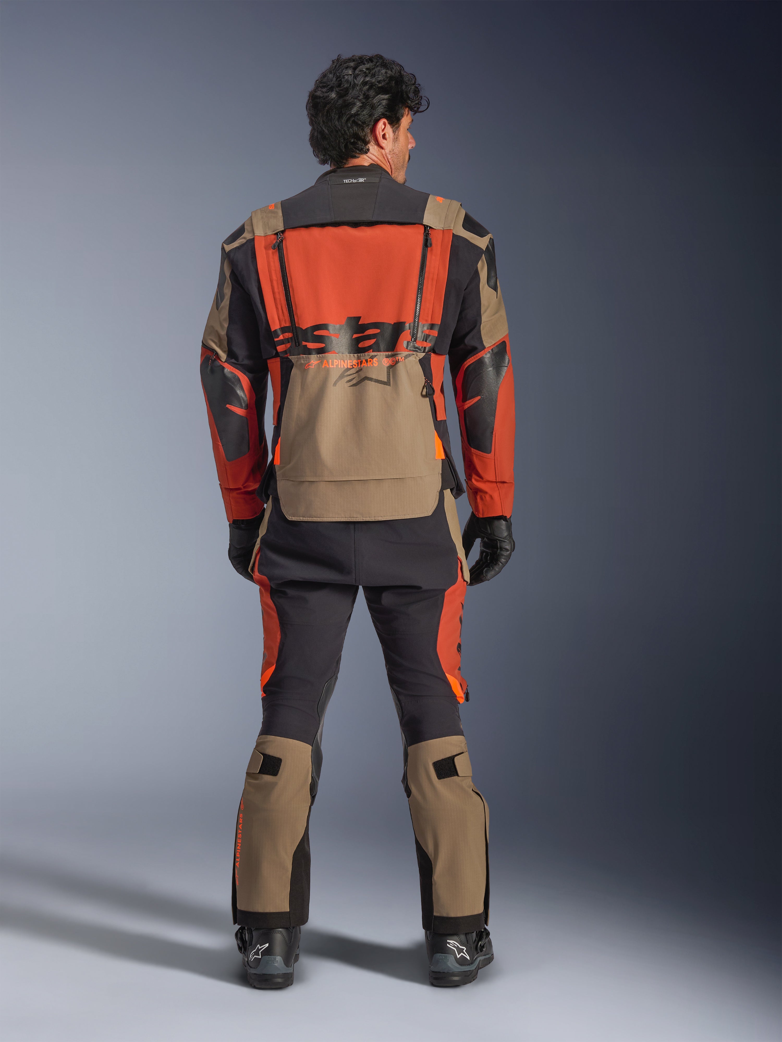 Alpinestars Halo Pro Drystar® XF Laminated Jacket, Walnut Rust Black, vy bakifrån, äventyrsjacka med modulär design och stor vattentät bakficka, bärs med matchande tekniska byxor.