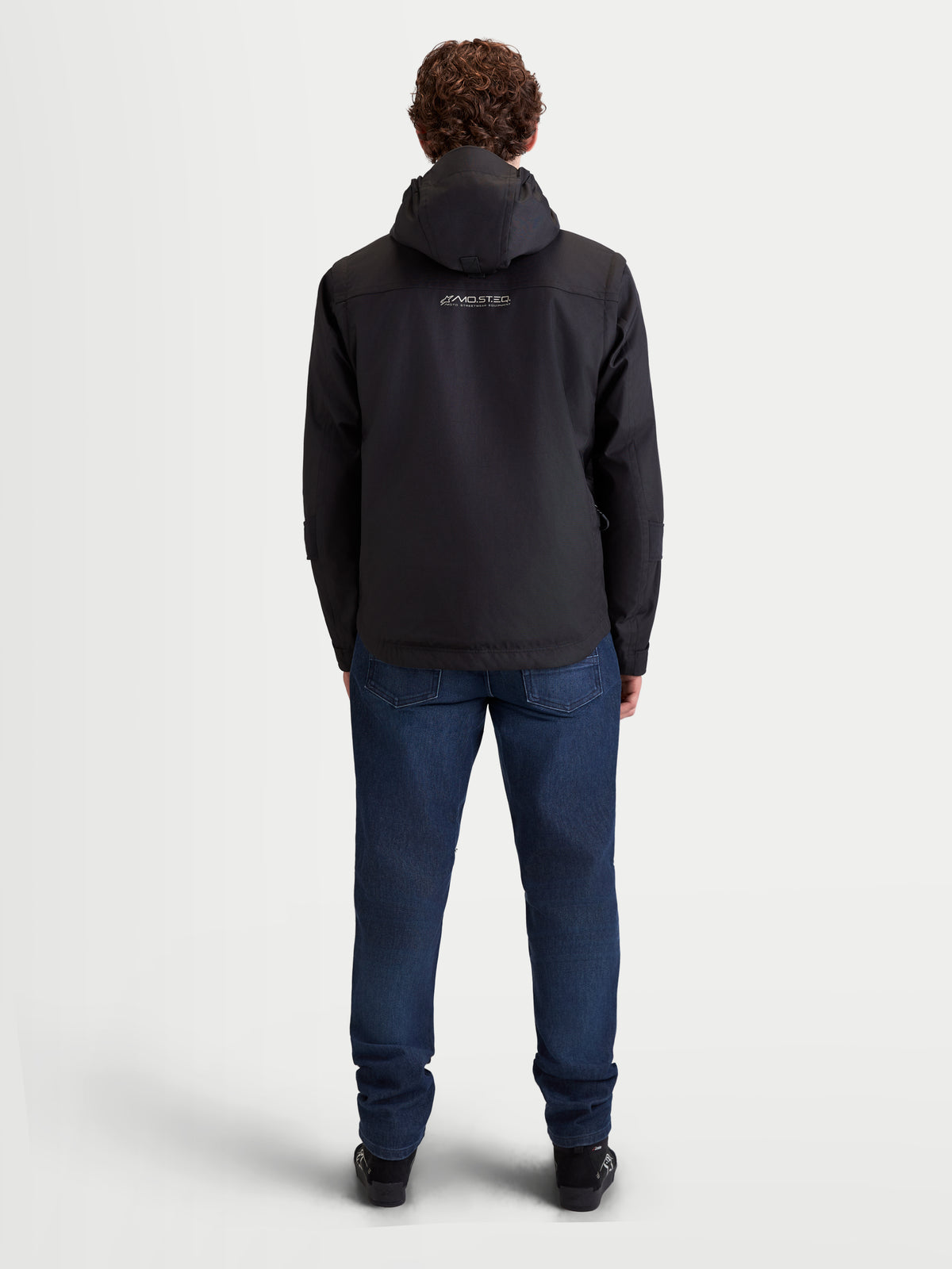 Alpinestars Morfex Parka Waterproof Jacket, men's urban contemporary motorcycle textile jacket in black, rear view on a model wearing the jacket with integrated hood and casual riding jeans.