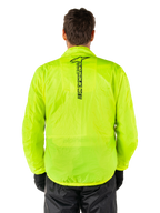 Alpinestars Hurricane Rain V2-jacka, regnjacka för motorcykel, Yellow Fluo, vy bakifrån som visar en vertikal svart Alpinestars-logotyp mitt på ryggen, lätt vattentätt material, bärs med svarta körbyxor och handskar