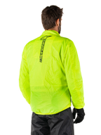 Alpinestars Hurricane Rain V2-jacka, gul fluo, ryggvy buren av manlig modell, med vertikalt svart Alpinestars-ordmärke mitt på ryggen, elastisk midja och ärmslut, vattentät och packbar design