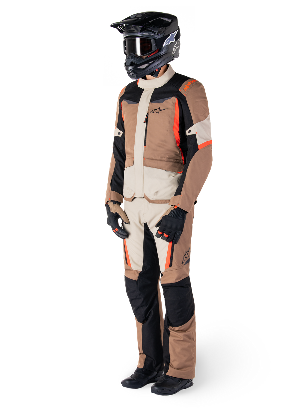 Alpinestars ST-1 Waterproof Jacket, Dark Khaki Sand Black Red Fluo, bärs av en förare i komplett adventure touring-utrustning med matchande byxor, svart hjälm, goggles, handskar och stövlar, teknisk allvädersoutfit för motorcykel