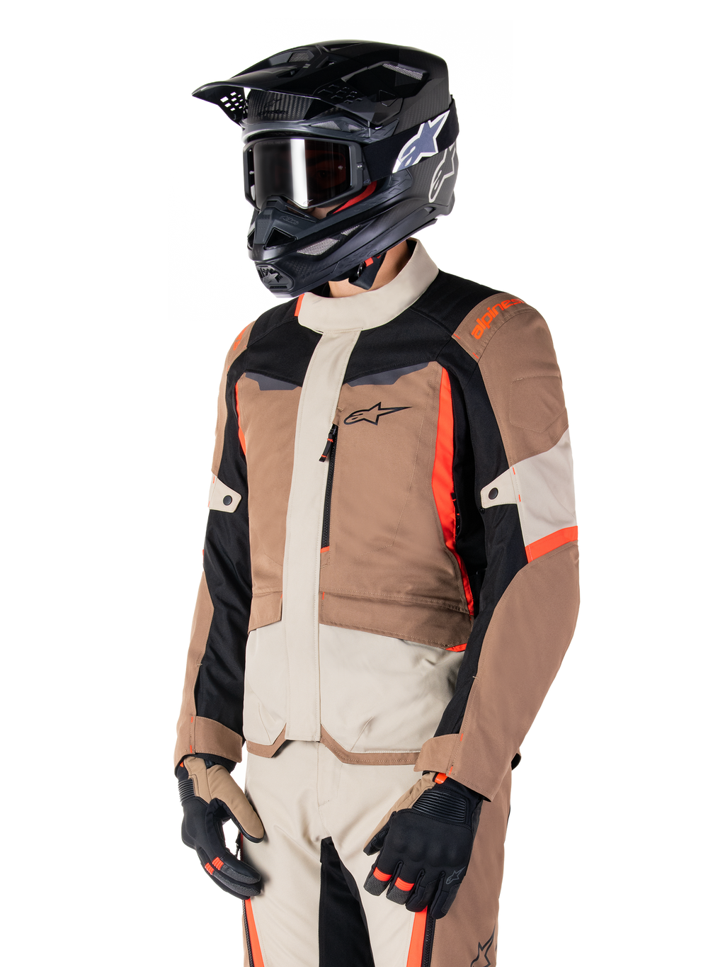 Alpinestars ST-1 Waterproof Jacket, adventure touring-jacka, mörk khaki, sand, svart och fluorescerande röd, bärs av en förare med svart motocrosshjälm och goggles, flerpanelsdesign med lastfickor och Alpinestars logotyp på bröstet