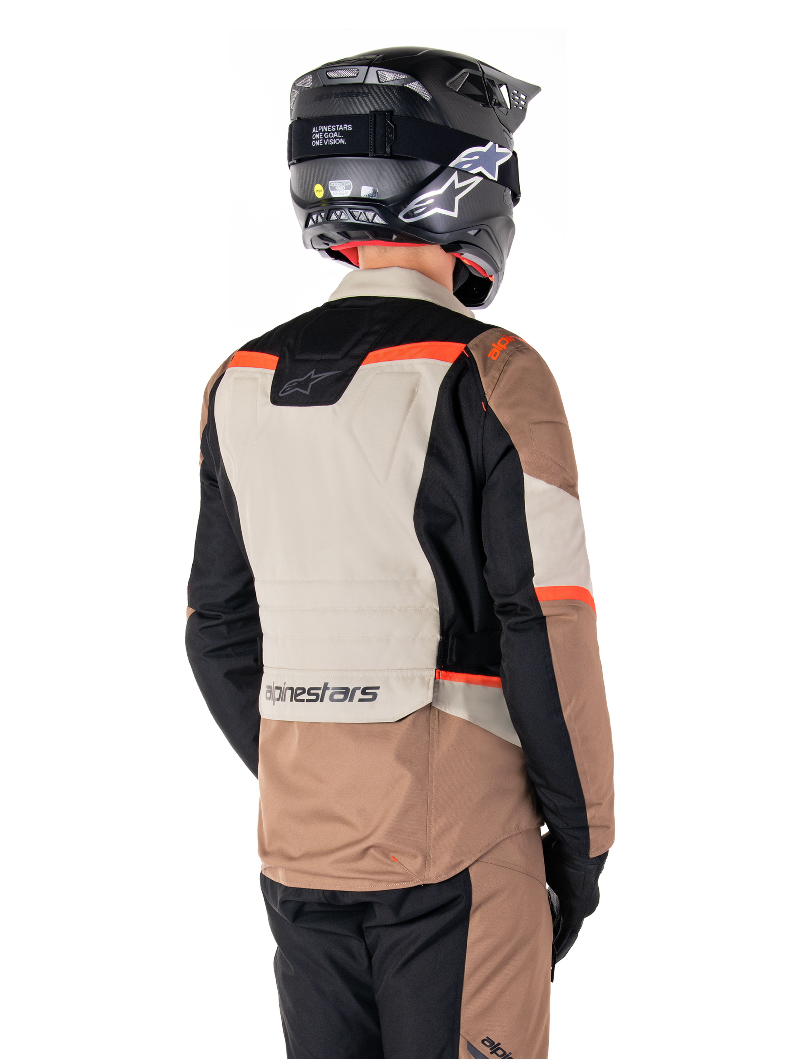 Alpinestars ST-1 Waterproof Jacket, adventure touring-jacka, Dark Khaki Sand Black Red Fluo, ryggvy som visar färgblockerade textilpaneler, fluorescerande röda detaljer och Alpinestars-logotyp på nedre ryggen, bärs av en förare med svart hjälm.