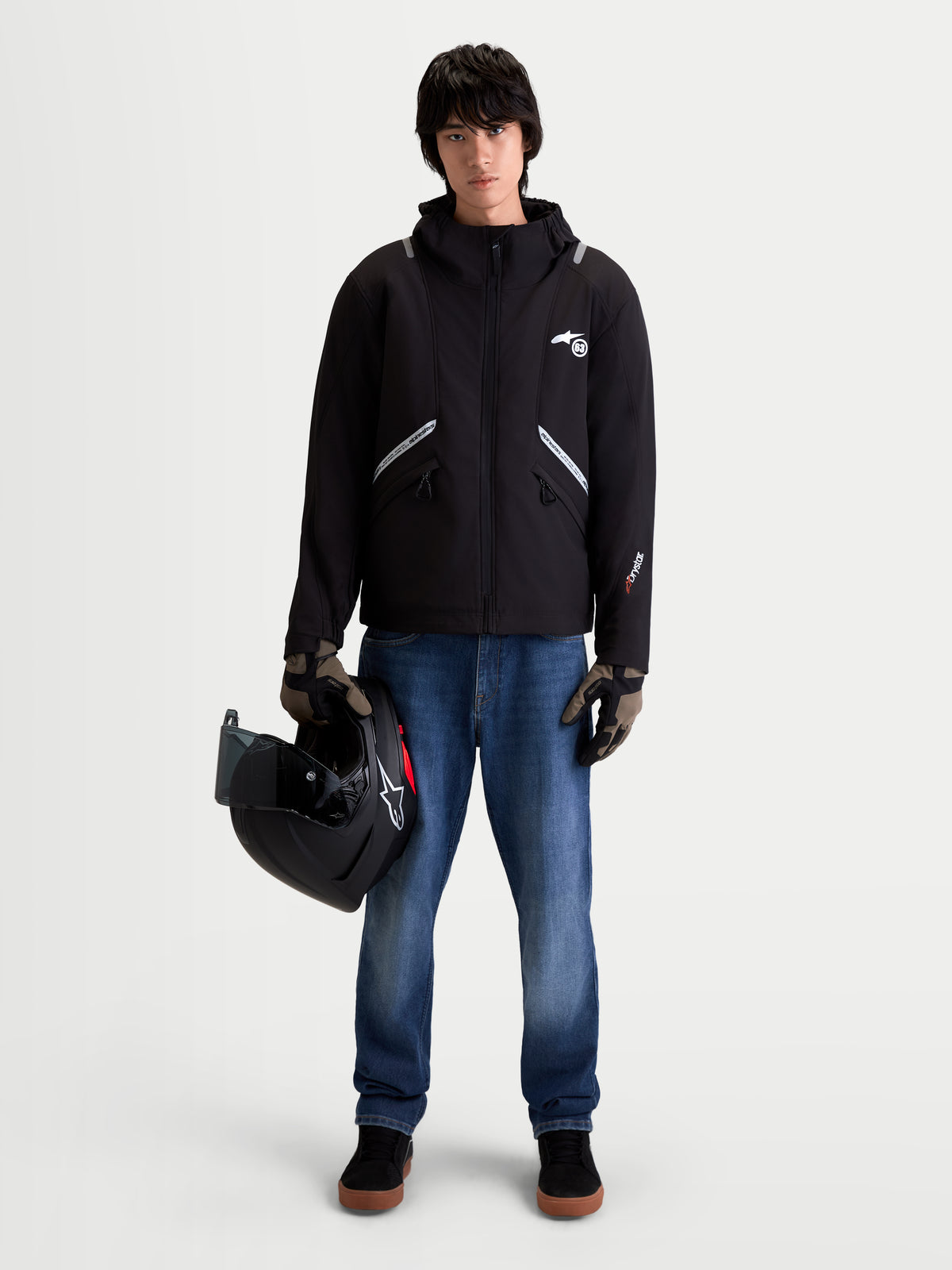 Alpinestars C-5 Drystar jacka, svart urban motorcykeljacka i softshell med huva, framifrån på en manlig modell som bär jeans, handskar och håller en hjälm