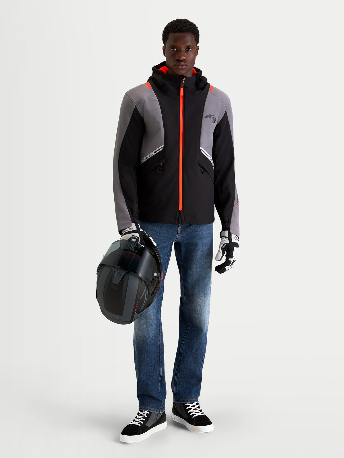 Alpinestars C-5 Drystar Jacket, men's urban contemporary motorcycle jacket in black and dark gray, front view on a model wearing jeans, gloves, and a helmet, holding a helmet.