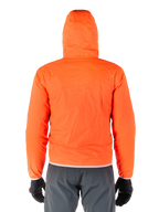 Alpinestars Mohobbs Waterproof Jacket, packbart regnskydd i lysande Orange Fluo, baksida av lättviktsjacka med huva, buren tillsammans med mörkgrå MC-byxor och svarta handskar