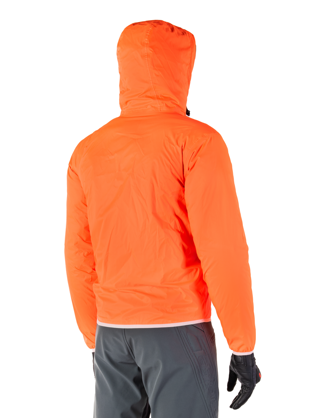 Alpinestars Mohobbs Waterproof Jacket, packbart regnfoder för nödlägen i stark Orange Fluo, vy bakifrån som visar stormsäker huva, bärs med mörkgrå MC-byxor och svarta handskar, lätt vattentät urban motorcykelutrustning