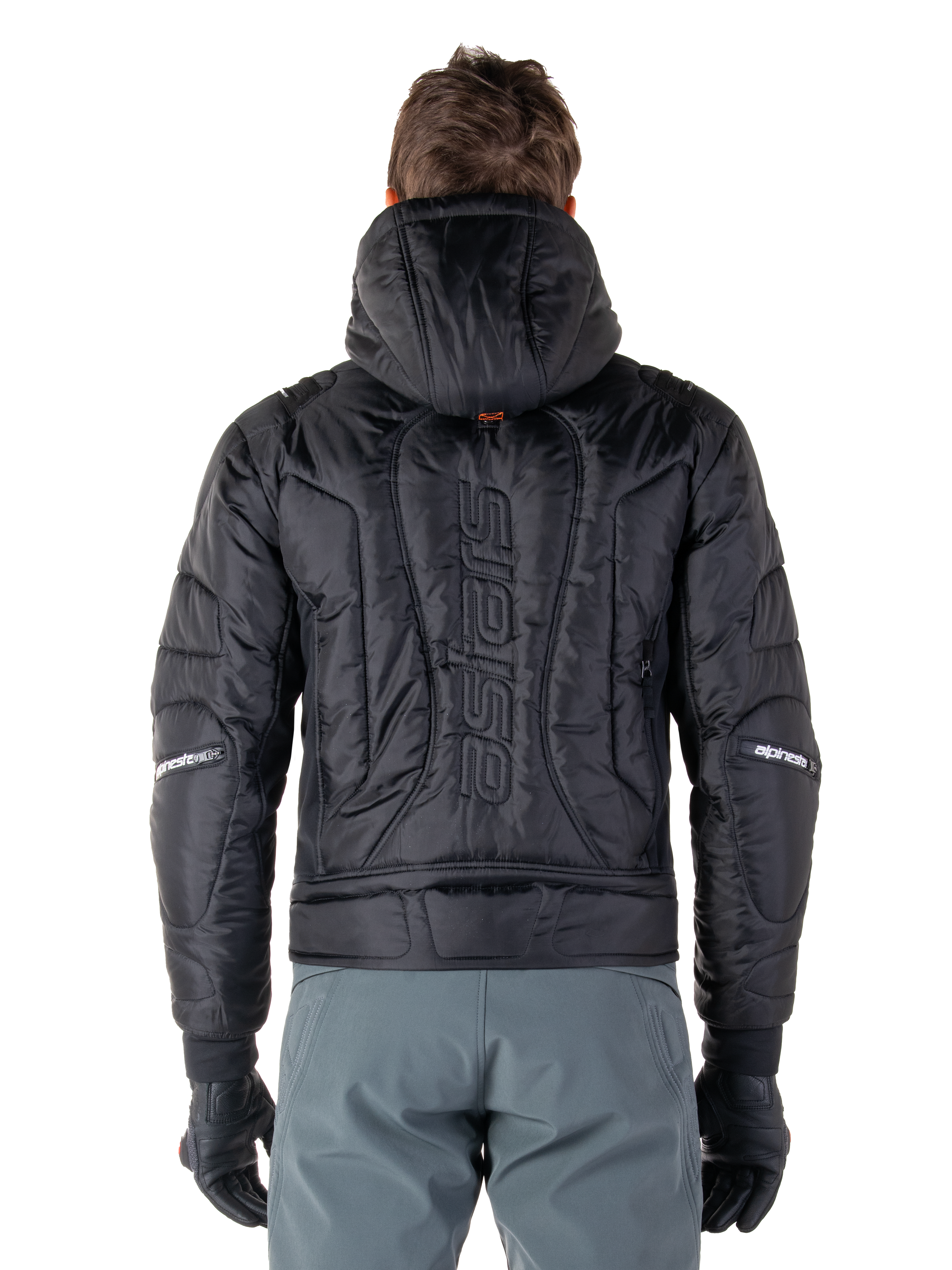 Alpinestars Mohobbs Waterproof Jacket, svart, vy bakifrån som visar quiltad och vadderad konstruktion, vertikalt 'astars'-ordmärke på ryggen, huvan uppe, modern moto-streetwear-stil