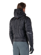 Alpinestars Mohobbs Waterproof Jacket, svart, vy bakifrån som visar quiltad vadderad konstruktion, huva, vertikalt astars-ordmärke på ryggen och Alpinestars-logotyper på ärmarna, bärs med gråa byxor och svarta handskar.