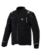 Alpinestars Andes Pro Drystar® XF-jacka, svart och mörkgrå äventyrsmotorcykeljacka, vy snett framifrån, med 'ALL TERRA'-logotyp på bröstet, reflekterande logotyper på axlarna, flera vattentäta fickor med dragkedja och justerbara ärmslut.
