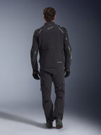 Alpinestars Andes Pro Drystar® XF-jacka, äventyrsjacka för touring, svart och mörkgrå, vy bakifrån som visar en stor cargoficka och förstärkta armbågspaneler, bärs med matchande svarta byxor och handskar, stilren funktionell design för körning i alla väder