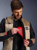 Alpinestars Andes Pro Drystar® XF-jacka i Walnut Aluminum, modell som demonstrerar det röda Nucleon-bröstskyddet i innerfickan, äventyrsmotorcykeljacka med ALL TERRA-logotyp och Drystar XF-logotyper.