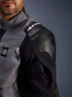 Alpinestars Andes Pro Drystar® XF-jacka, äventyrsmotorcykeljacka, mörkgrå och svart, närbild av förstärkt axel med Alpinestars-branding, 'TERRA'-logotyp och ventilationsöppning med dragkedja på ärmen på tekniskt textilskal.