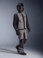 Äventyrsförare som bär Alpinestars Andes Pro Drystar® XF-jackan i mörkgrått och svart, matchande grå och svarta äventyrsbyxor, svart helhjälm med goggles och svarta motorcykelhandskar, studiobild för professionell utrustning för långdistanstouring.