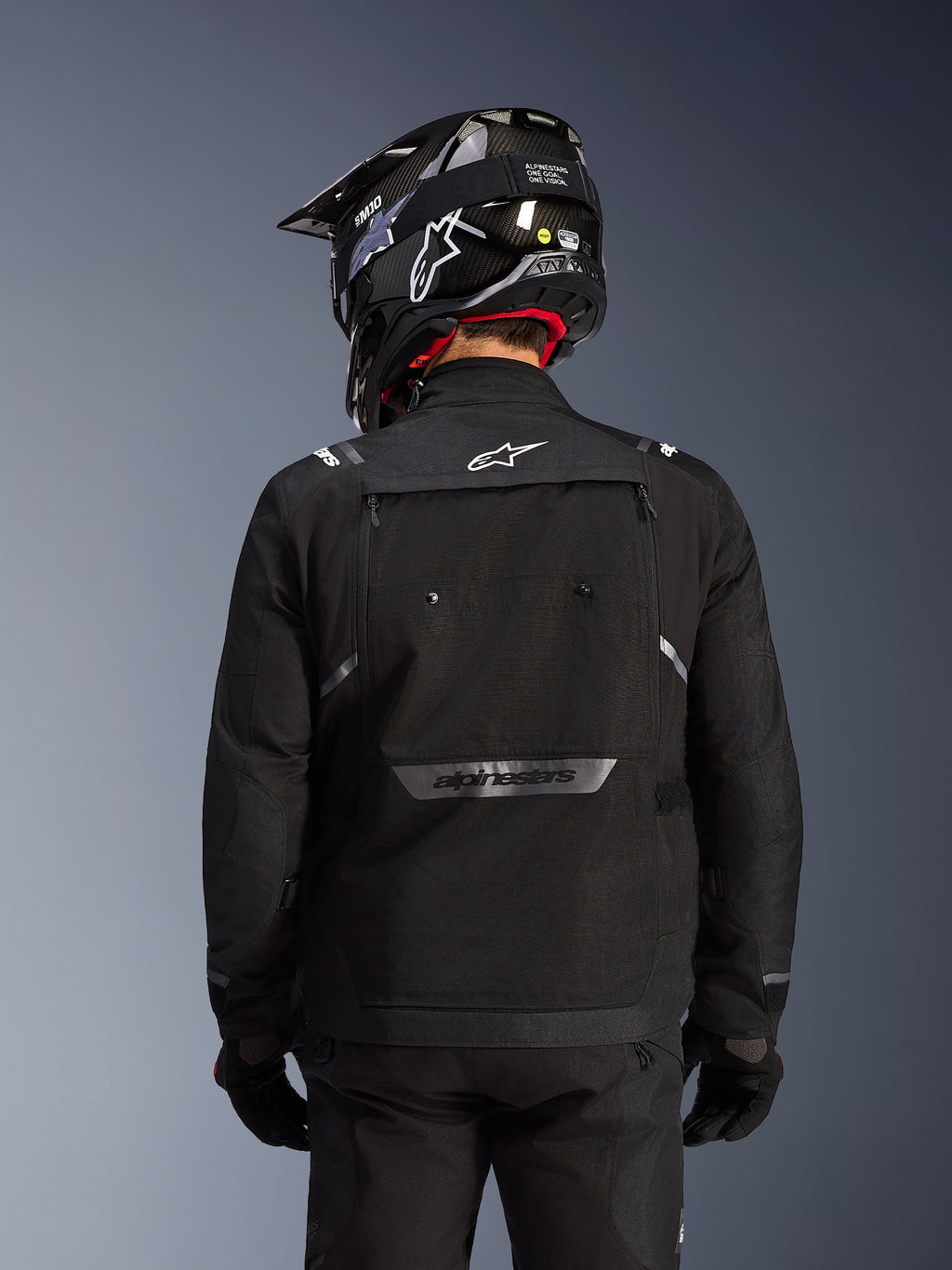 Alpinestars Cusco Drystar® Jacket, Black, Back view of a rider wearing a black helmet and gloves, features large ventilation panels, white logo on the neck and reflective branding on the lower back, adventure touring gear
