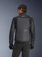 Alpinestars Cusco Drystar®-jacka, motorcykeljacka, svart och mörkgrå, ryggvy på en modell som visar en stor grå ryggpanel, vit Alpinestars-logotyp och blå detaljer på ärmarna.