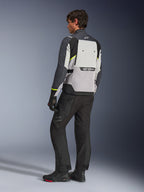 Alpinestars Cusco Drystar®-jacka i Ice Gray, Mid Gray och Deep Gray, sedd bakifrån på modell, adventure touring-jacka med neongula detaljer, bärs med svarta MC-byxor och stövlar, med en stor ventilationspanel på ryggen och Alpinestars-profilering.