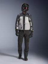 Alpinestars Cusco Drystar®-jacka, Ice Gray Mid Gray Deep Gray, äventyrsmotorcykeljacka som bärs med svarta MC-byxor, svarta handskar och en svart hjälm med goggles, med färgblockerade grå paneler och tekniska detaljer för väg- och äventyrstouring.