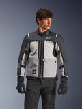 Alpinestars Cusco Drystar® jacka, adventure touring-motorcykeljacka, färgerna Ice Gray, Mid Gray och Deep Gray, bärs av en modell med svarta byxor och handskar, teknisk textildesign i flera paneler, bröstfickor, 'Drystar'-logotyp på ärmen och subtila neongula detaljer vid ärmsluten.