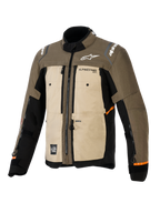 Alpinestars Cusco Drystar®-jacka, Walnut Aluminum Black, motorcykeljacka för äventyrstouring, trekvartsvy framifrån, textilkonstruktion med beigea och bruna paneler, ventilationsöppningar med dragkedja, vita Alpinestars-logotyper och orangea detaljer på ärmarna