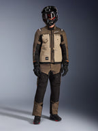 Alpinestars Cusco Drystar®-jacka, Walnut Aluminum Black, adventure touring MC-jacka som bärs med matchande byxor och en svart hjälm, med beige bröstpaneler och bruna ripstop-ärmar, teknisk allvädersutrustning